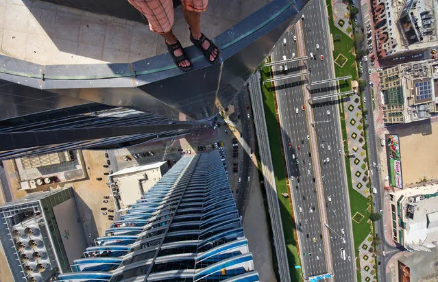 One of the Daredevils legs dangling from a building in Dubai. (Photo by Alexander Remnev/Caters News)