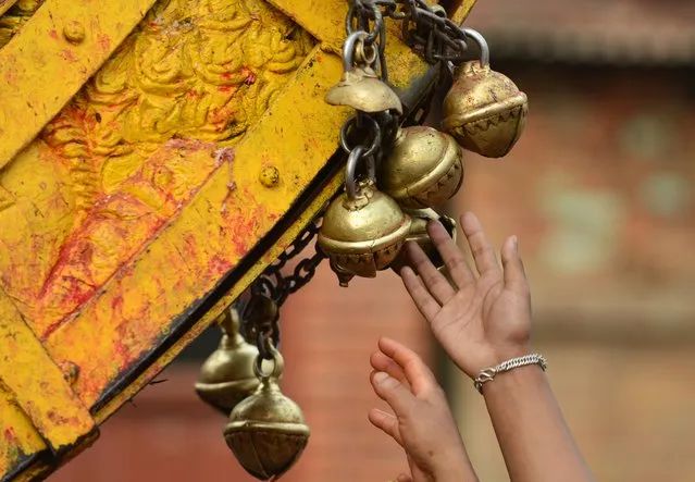 Nepalese revellers ring bells on a wooden chariot during celebrations for the Nepalese New Year or “Bisket Jatra” in Bhaktapur, some 12 kms east of Kathmandu, on April 14, 2017. The festival which began April 10, is celebrated for nine days by the ethnic Newar community in Bhaktapur. (Photo by Prakash Mathema/AFP Photo)