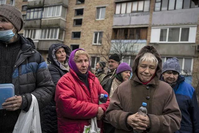 A group of women wait to receive free food from a soup kitchen in Bucha, in the outskirts of Kyiv, Ukraine, Saturday, April 9, 2022. (Photo by Rodrigo Abd/AP Photo)