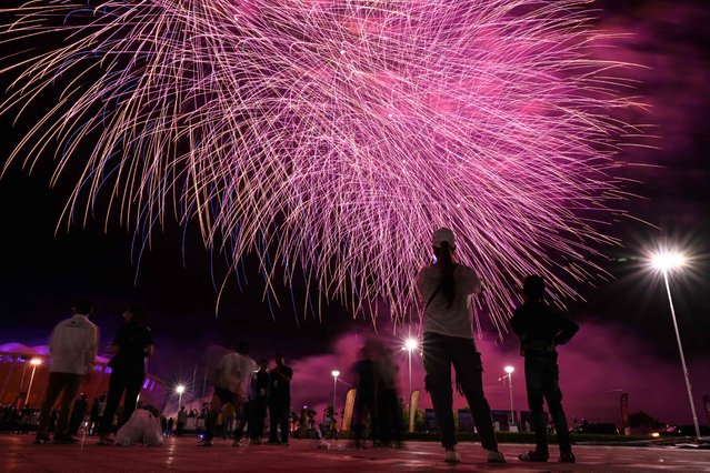 People watch fireworks exploding during the closing ceremony of the 32nd Southeast Asian Games (SEA Games) at the Morodok Techo National Stadium in Phnom Penh on May 17, 2023. (Photo by Mohd Rasfan/AFP Photo)