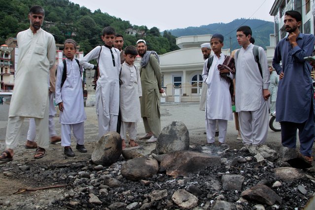 Local residents look at a spot where a Muslim mob lynched and burned a man over allegations that he had desecrated Islam's holy book, the Quran, in Madyan in Pakistan's Khyber Pakhtunkhwa province, Friday, June 21, 2024. The attackers also torched a police station which had held the man in Madyan and burned police vehicles parked there, according to local police official Rahim Ullah. (Photo by Naveed Ali/AP Photo)