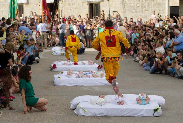 A man representing the devil leaps over babies during the festival of El Salto del Colacho (the devil's jump) on June 22, 2014 in Castrillo de Murcia, Spain. The festival, held on the first Sunday after Corpus Cristi, is a catholic rite of the devil cleansing babies of original sin. (Photo by Denis Doyle/Getty Images)