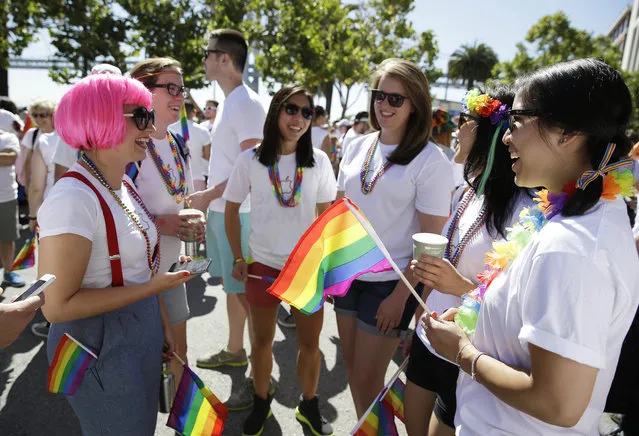 A group of Apple Computer employees gather before the start of the 44th annual San Francisco Gay Pride parade Sunday, June 29, 2014, in San Francisco. The lesbian, gay, bisexual, and transgender celebration and parade is one of the largest LGBT gatherings in the nation. (Photo by Eric Risberg/AP Photo)
