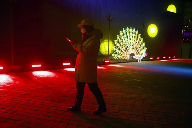 A man walks near a light sculpture before a New Year's Eve countdown event at the 2022 Beijing Winter Olympic headquarters in Bejiing, Tuesday, December 31, 2019. Revelers around the globe are bidding farewell to a decade that will be remembered for the rise of social media, the Arab Spring, the #MeToo movement and, of course, President Donald Trump. (Photo by Ng Han Guan/AP Photo)