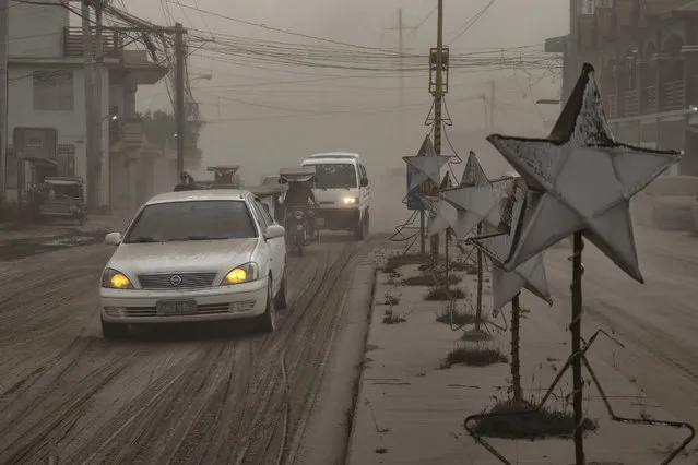 Motorists drive through a road covered in volcanic ash from Taal Volcano's eruption on January 13, 2020 in Lemery, Batangas province, Philippines. (Photo by Ezra Acayan/Getty Images)