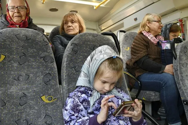 People sit in a bus during an evacuation of civilians on a road near Slovyansk, eastern Ukraine, Wednesday, May 4, 2022. (Photo by Andriy Andriyenko/AP Photo)