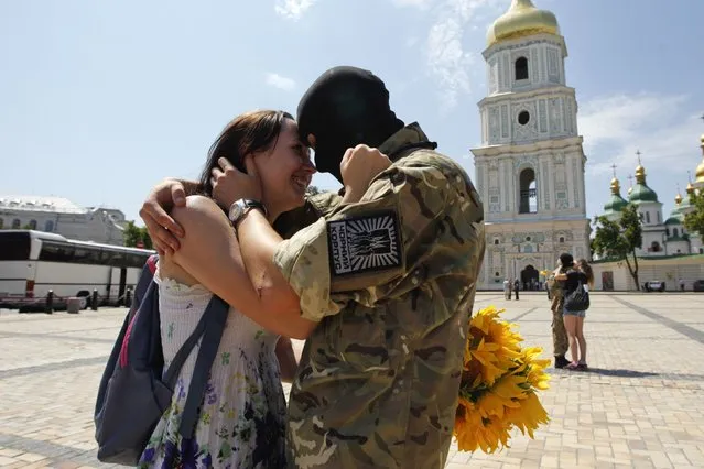 A new volunteer of Ukrainian self-defence battalion “Azov” embraces his girlfriend after a ceremony where he took an oath of allegiance to the country, in Kiev July 16, 2014. The volunteer would shortly head to eastern Ukraine. (Photo by Valentyn Ogirenko/Reuters)
