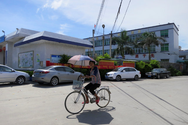 A villager cycles outside a police station in Wukan village in China's Guangdong province, June 20, 2016. (Photo by James Pomfret/Reuters)