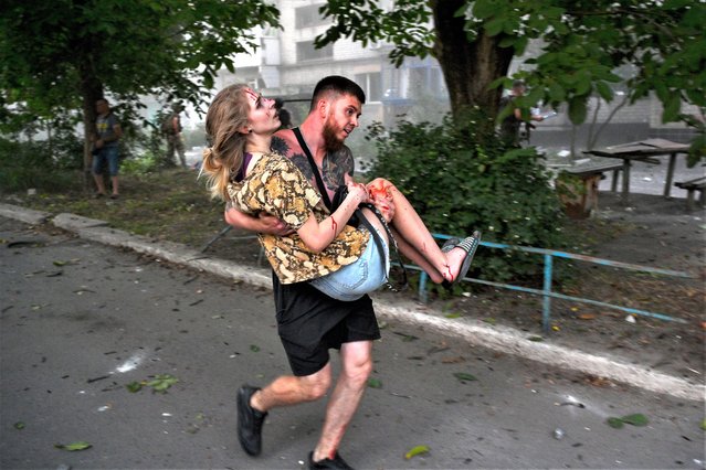 A man carries an injured Ukrainian woman after an explosion of a second rocket in the city of Pokrovsk, Donetsk area, Ukraine, 07 August 2023, amid the Russian invasion. At least five people died and 31 were injured after two rockets hit a residential building and a hotel downtown, according to a National Police report. Russian troops entered Ukrainian territory in February 2022, starting a conflict that has provoked destruction and a humanitarian crisis. (Photo by Stanislav Krupar/EPA/EFE)