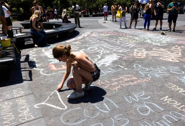 An abortion rights supporter writes on the ground at Washington Square Park in protest, after the United States Supreme Court ruled in the Dobbs v Women's Health Organization abortion case, overturning the landmark Roe v Wade abortion decision, in New York, U.S., June 24, 2022. (Photo by Caitlin Ochs/Reuters)