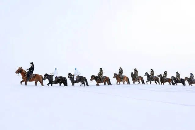 This photo taken on February 19, 2020 shows police officers wearing protective face masks riding horses on their way to visit residents who live in remote areas in Altay, farwest China's Xinjiang region, to promote the awareness of the virus. The death toll from China's new coronavirus epidemic jumped to 2,112 on February 20 after 108 more people died in Hubei province, the hard-hit epicentre of the outbreak. (Photo by AFP Photo/China Stringer Network)