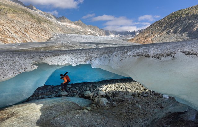 Glaciologist at ETHZ and head of Glacier Monitoring in Switzerland (GLAMOS) Matthias Huss enters an ice cave at the tongue of the Rhone glacier amid climate change in Obergoms, Switzerland on August 27, 2024. (Photo by Denis Balibouse/Reuters)