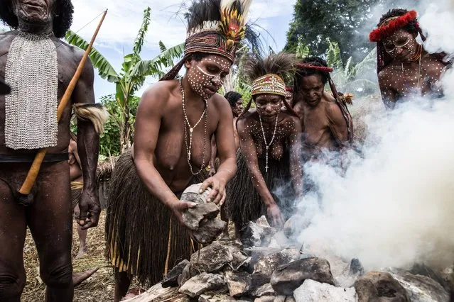 People from the Dani tribe burn stones at Obia Village on August 9, 2014 in Wamena, Papua, Indonesia. (Photo by Agung Parameswara/Getty Images)