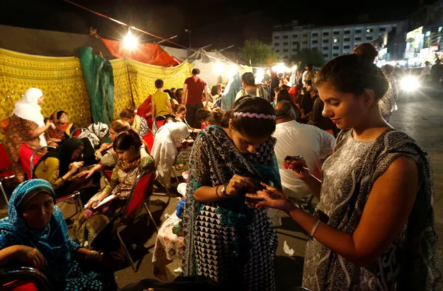 Women get Henna tattoos (Mehndi) ahead of Eid al-Fitr, which marks the end of the Muslim holy fasting month of Ramadan, at a market in Islamabad, Pakistan July 6, 2016. (Photo by Caren Firouz/Reuters)