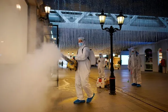 Volunteers in protective suits disinfect a shopping complex in Wuhan, Hubei province, the epicentre of China's coronavirus disease (COVID-19) outbreak, March 31, 2020. (Photo by Aly Song/Reuters)
