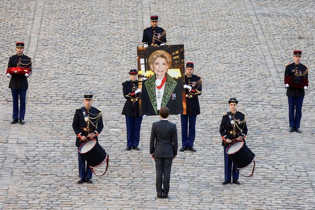 French President Emmanuel Macron (C) stands as Republican Guards carry a portrait of late French historian and perpetual secretary of the Academie Francaise (French Academy) Helene Carrere d'Encausse during a national homage in her tribute at the Hotel des Invalides in Paris, on October 3, 2023. (Photo by Ludovic Marin/AFP Photo)