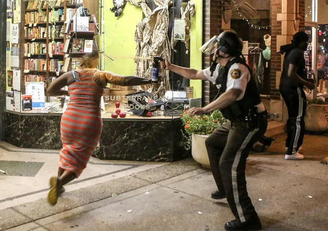 A protester is sprayed with mace by riot police after throwing a chair through a window of a business during the second night of demonstrations after a not guilty verdict in the murder trial of former St. Louis police officer Jason Stockley, charged with the 2011 shooting of  Anthony Lamar Smith, who was black, in St. Louis, Missouri, U.S., September 16, 2017. (Photo by Lawrence Bryant/Reuters)