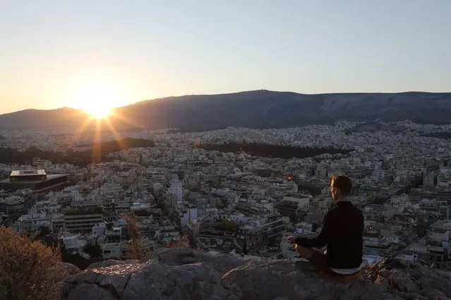 This photograph taken early September 7, 2017, shows man practicing meditation on La Pnyx Hill in Athens. (Photo by Ludovic Marin/AFP Photo)