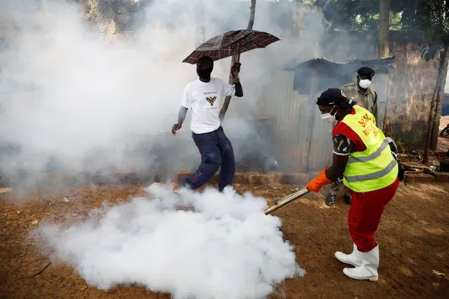 A volunteer from Nairobi's governor Sonko rescue team sprays disinfectants to help fight the spread of the coronavirus disease (COVID-19) at the Raila Educational Centre in the Kibera slums in Nairobi, Kenya, April 18, 2020. (Photo by Baz Ratner/Reuters)