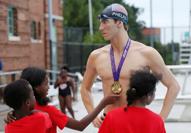 Young swimmers admire a Madame Tussauds Museum figure of U.S. Olympic gold medal swimmer Michael Phelps at Banneker Pool in Washington, U.S., to coincide with the opening of the Rio Olympics August 5, 2016. (Photo by Gary Cameron/Reuters)