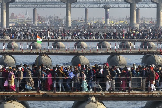 Hindu devotees cross pontoon bridges as they arrive for bathing at the confluence of the Ganges, the Yamuna, and the Saraswati rivers during the 45-day-long Maha Kumbh festival in Prayagraj, India, Sunday, January 26, 2025. (Photo by Rajesh Kumar Singh/AP Photo)