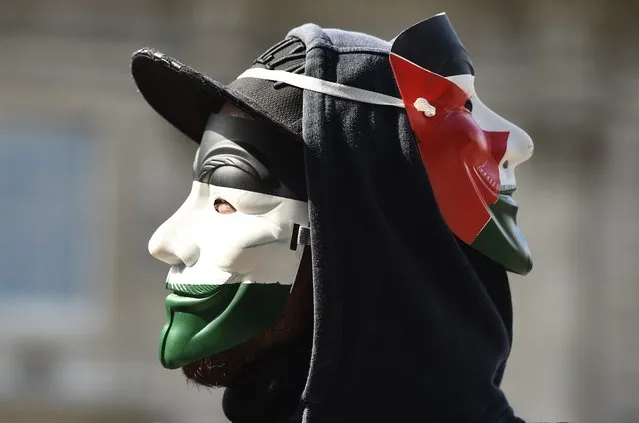 A demonstrator wears Guy Fawkes masks painted in the colours of the Palestinian flag during a protest outside Downing Street in London, Britain September 9, 2015. (Photo by Toby Melville/Reuters)