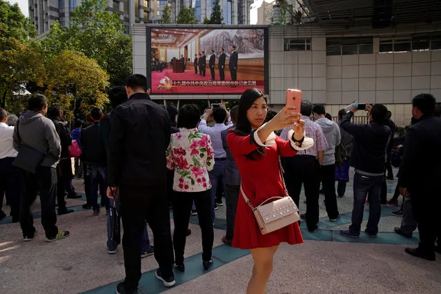 A woman takes a selfie in front of a TV screen showing a live broadcast of Xi Jinping’s address in Beijing, Wednesday, October 25, 2017 (Photo by Aly Song/Reuters)