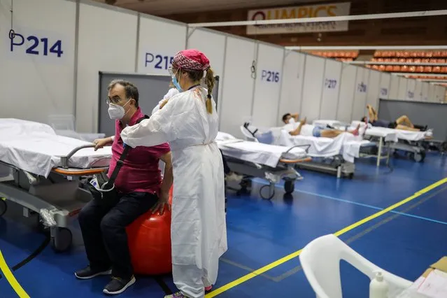 Daniel Catey, 62, a recovered COVID-19 patient, undergoes rehabilitation with a physical therapist at the Hospital Vall d'Hebron facility, a hastily converted sports centre, in Barcelona, Spain, June 11, 2020. (Photo by Nacho Doce/Reuters)