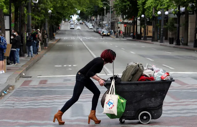 A woman pushes a cart during a protest against racial inequality and call for defunding of Seattle police, in Seattle downtown, Washington, U.S. June 14, 2020. (Photo by Goran Tomasevic/Reuters)