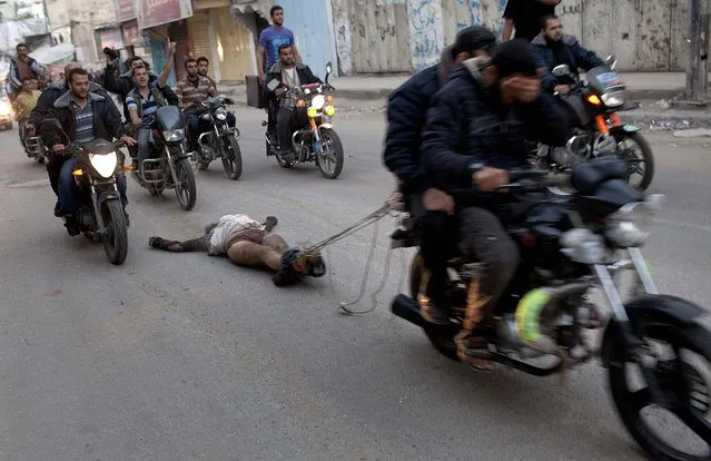 The body of a suspected collaborator is dragged through the streets behind a motorcycle in Gaza City on Tuesday. As the Palestinian death toll climbed by late Tuesday morning to 112, according to the Health Ministry in Gaza, the White House announced Secretary of State Hillary Rodham Clinton would travel to the Middle East to try to defuse the conflict. (Photo by Tyler Hicks/The New York Times)
