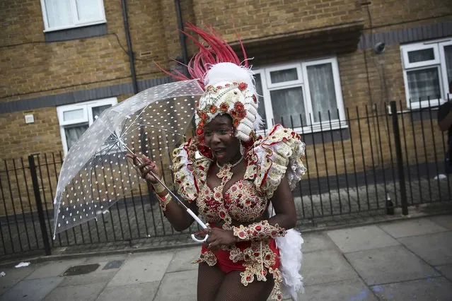 A performer reacts during a rain shower as she participates in the parade at the Notting Hill Carnival in London, Britain August 29, 2016. (Photo by Neil Hall/Reuters)