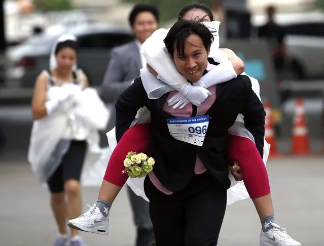 Thai groom-to-be Nutthawut Nakajun carries his bride-to-be Jirawan Kirdsang as they compete in the “Running of the Brides” event in Bangkok, Thailand, 02 December 2017. (Photo by Rungroj Yongrit/EPA/EFE/Rex Features/Shutterstock)