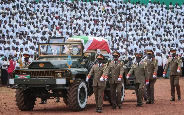 The coffin, covered with he Burundi national flag, of late Burundi President Pierre Nkurunziza, who died at the age of 55, is presented on a ceremonial vehicle during the national funeral at the Ingoma stadium in Gitega, Burundi, on June 26, 2020. (Photo by Tchandrou Nitanga/AFP Photo)