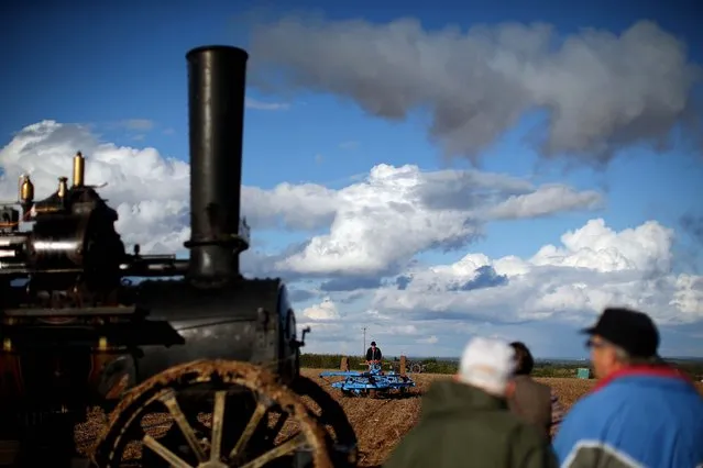 A ploughman demonstrates with a cultivator or “Scuffle” (R) drawn by a 1917 Fowler AA7 Steam Plough engine on day one of the 2014 “British National Ploughing Championships” on October 11, 2014 in Basingstoke, England. Over 200 ploughmen and women from across the country compete over two days in a range of classes on the 200 acre site in Hampshire. (Photo by Dan Kitwood/Getty Images)