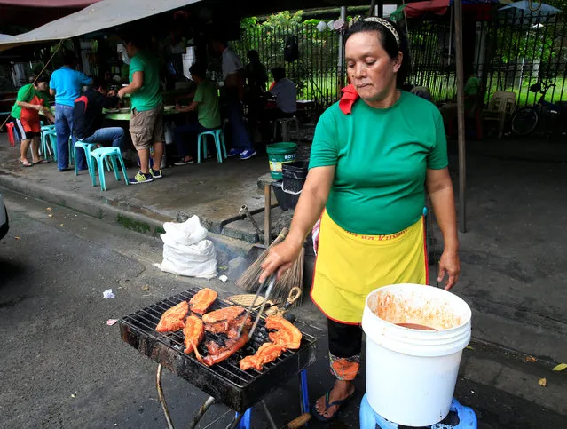 A street food vendor prepares grilled pork crops at a food stall along a main street in Metro Manila, Philippines, August 4, 2016. (Photo by Romeo Ranoco/Reuters)