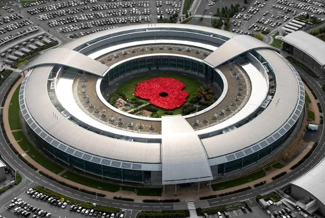 Undated handout aerial photo issued by the Government Communications Headquarters (GCHQ) of around 1400 GCHQ staff, both civilian and military, wearing red ponchos, green combat dress and black uniforms to form a giant poppy in the centre of the GCHQ “doughnut” building in Cheltenham, Gloucestershire to launch this years Royal British Legion Gloucestershire County Poppy Appeal. (Photo by GCHQ/Crown Copyright/PA Wire)