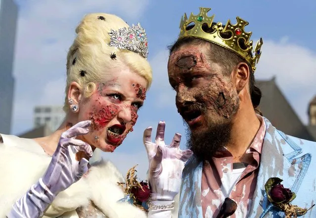 Participants dressed up as zombies pose for photos during the 2014 Toronto Zombie Walk in Toronto, Canada, October 25, 2014. Over 10,000 participants dressed up as zombies walked down the streets of Toronto to celebrate Halloween on Saturday. (Photo by Zou Zheng/Xinhua)
