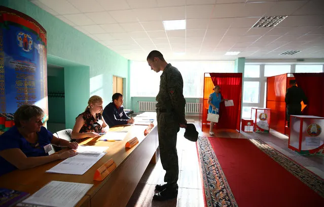A Belarussian serviceman receives his ballot at a polling station during a parliamentary election, in Minsk, Belarus September 11, 2016. (Photo by Vasily Fedosenko/Reuters)