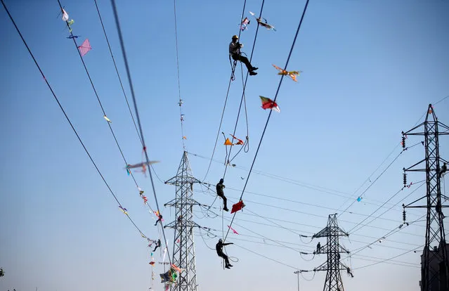 Workers of Torrent Power Limited remove kites and thread tangled up in electric power cables after the end of the kite flying season in Ahmedabad, India, January 18, 2018. (Photo by Amit Dave/Reuters)