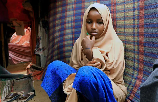 Nurta Mohamed, 13, a Somali girl sits inside her mother's makeshift shelter after she ran away from a suspected forced marriage at the Alafuuto camp for internally displaced persons in Garasbaaley district of Mogadishu, Somalia on August 14, 2020. (Photo by Feisal Omar/Reuters)