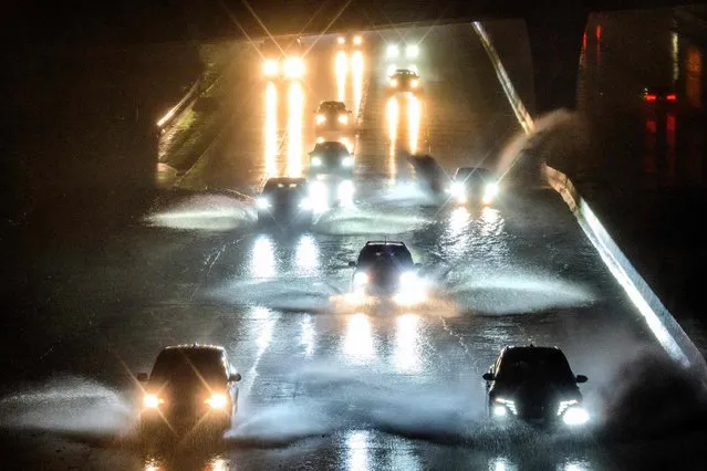 Drivers barrel into standing water on Interstate 101 in San Francisco, California on January 4, 2023. A bomb cyclone smashed into California on January 4, 2023, bringing powerful winds and torrential rain that was expected to cause flooding in areas already saturated by consecutive storms. (Photo by Josh Edelson/AFP Photo)
