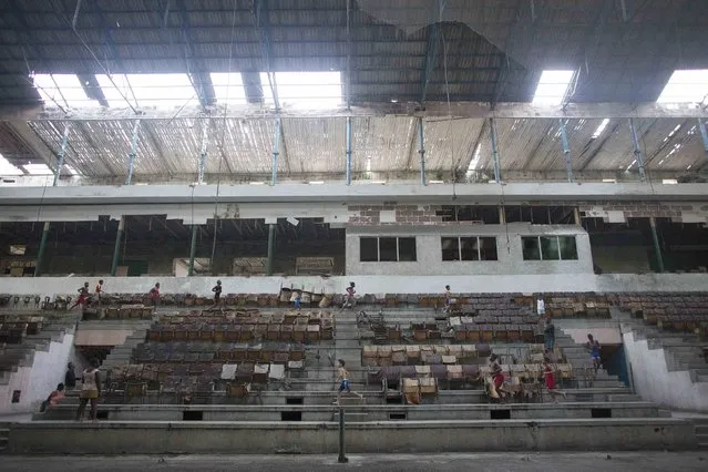 Children exercise before a wrestling practice session at an old Basque ball game gymnasium in downtown Havana, November 13, 2014. (Photo by Alexandre Meneghini/Reuters)