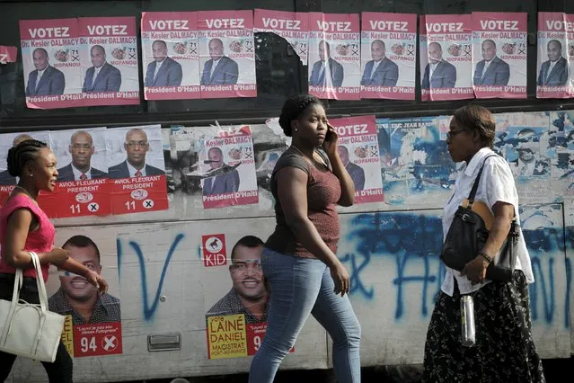 Women walk next to posters of candidates running for elections plastered on a bus along a street in Port-au-Prince, Haiti, October 20, 2015. Haiti will hold elections on October 25. (Photo by Andres Martinez Casares/Reuters)