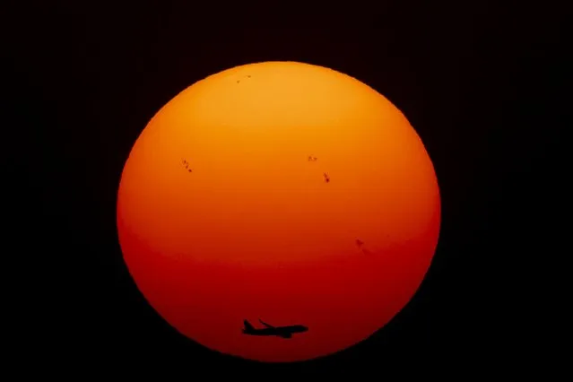 A commercial aircraft approaches the runway as the sun sets for the last time in 2022, in New Delhi, India, Saturday, December 31, 2022. (Photo by Altaf Qadri/AP Photo)