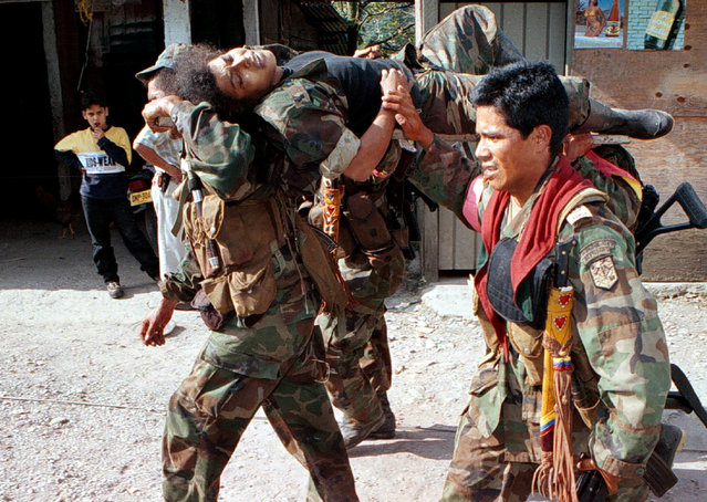 Colombian soldiers carry a guerrilla injured in combat during an attack in Guayabetal Meta province, 60 km southeast of Bogota, January 15, 2000. (Photo by Reuters/Stringer)