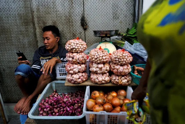An onion seller sits and waits for customers at a morning market in Jakarta, Indonesia, October 3, 2016. (Photo by Reuters/Beawiharta)