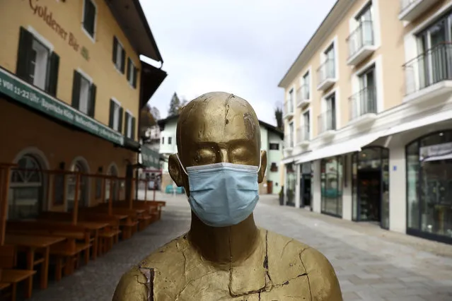 A art sculpture wearing a face mask in the deserted city of Berchtesgaden, Germany, Monday, October 26, 2020. Authorities have posed the Berchtesgaden region under a lockdown since Oct. 20, 2020 due to a rising number of cases of the pandemic COVID-19 disease caused by the SARS-CoV-2 coronavirus in the district of Berchtesgadener Land. Local authorities in Bavaria's Rottal-Inn county, on the border with Austria, said Monday that the restrictions will begin at midnight. (Photo by Matthias Schrader/AP Photo)