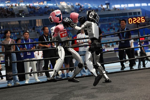 Unitree Robotics humanoid robots compete in a kickboxing match at the inaugural World Humanoid Robot Games, at the National Speed Skating Oval in Beijing, China on August 15, 2025. (Photo by Tingshu Wang/Reuters)