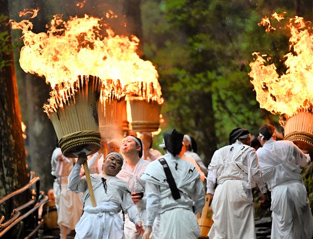 Shrine parishioners hold big flaming torches to purify the path for portable shrines during the Ogi Matsuri Festival, aka Kumano Nachi Fire Festival at Kumamo Nachi Taisha Shrine on July 14, 2025 in Nachikatsuura, Wakayama, Japan. The festival is originated 1,500 years ago. (Photo by The Asahi Shimbun via Getty Images)