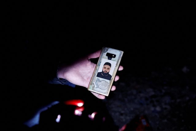 Mustafa Kazzaz, originally from Syria, holds a picture of his brother who died, along with the rest of his family, in the earthquake, when their apartment block collapsed, and now Kazzaz stays in a tent at the site of their former home, in the aftermath of a deadly earthquake, in Antakya, Hatay province, Turkey on February 21, 2023. (Photo by Clodagh Kilcoyne/Reuters)